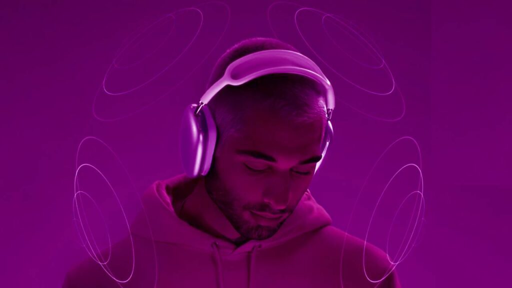Homem com fones de ouvido modernos, envolvido por gráficos de som espacial que simbolizam a experiência de áudio tridimensional