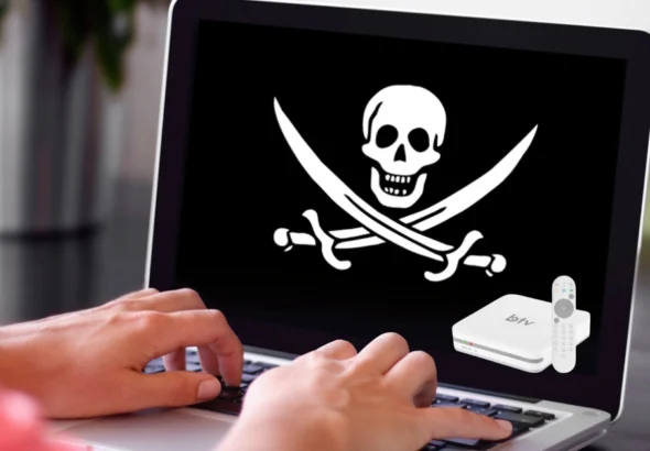 Mãos de usuário digitando em notebook com símbolo de pirataria (caveira) na tela e imagem ilustrativa de aparelho BTV Box e controle remoto no canto.